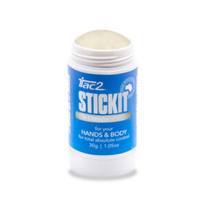 Close-up of a blue and white cylindrical container with the cap removed, exposing a beige paste at the top (Extra Strength Sports Grip).