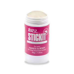 Close-up of a pink cosmetic container with a white cap, the beige balm inside is exposed as a solid stick.
