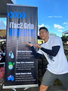 Holding dragon boat paddle grip in front of iTac2 benefits banner